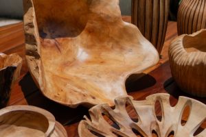 Artistic wooden bowls and vases arranged on a table outdoors, showcasing craftsmanship.