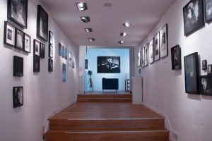 Stylish art gallery interior featuring steps and framed pictures on white walls, creating a serene atmosphere.